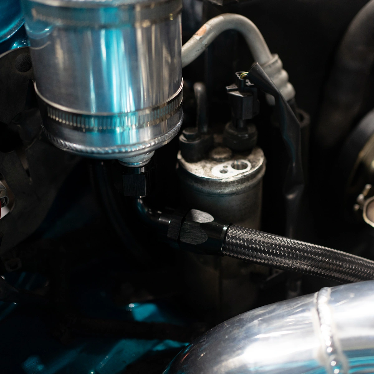 Close-up of braided fuel hose with AN fitting in a modified engine bay